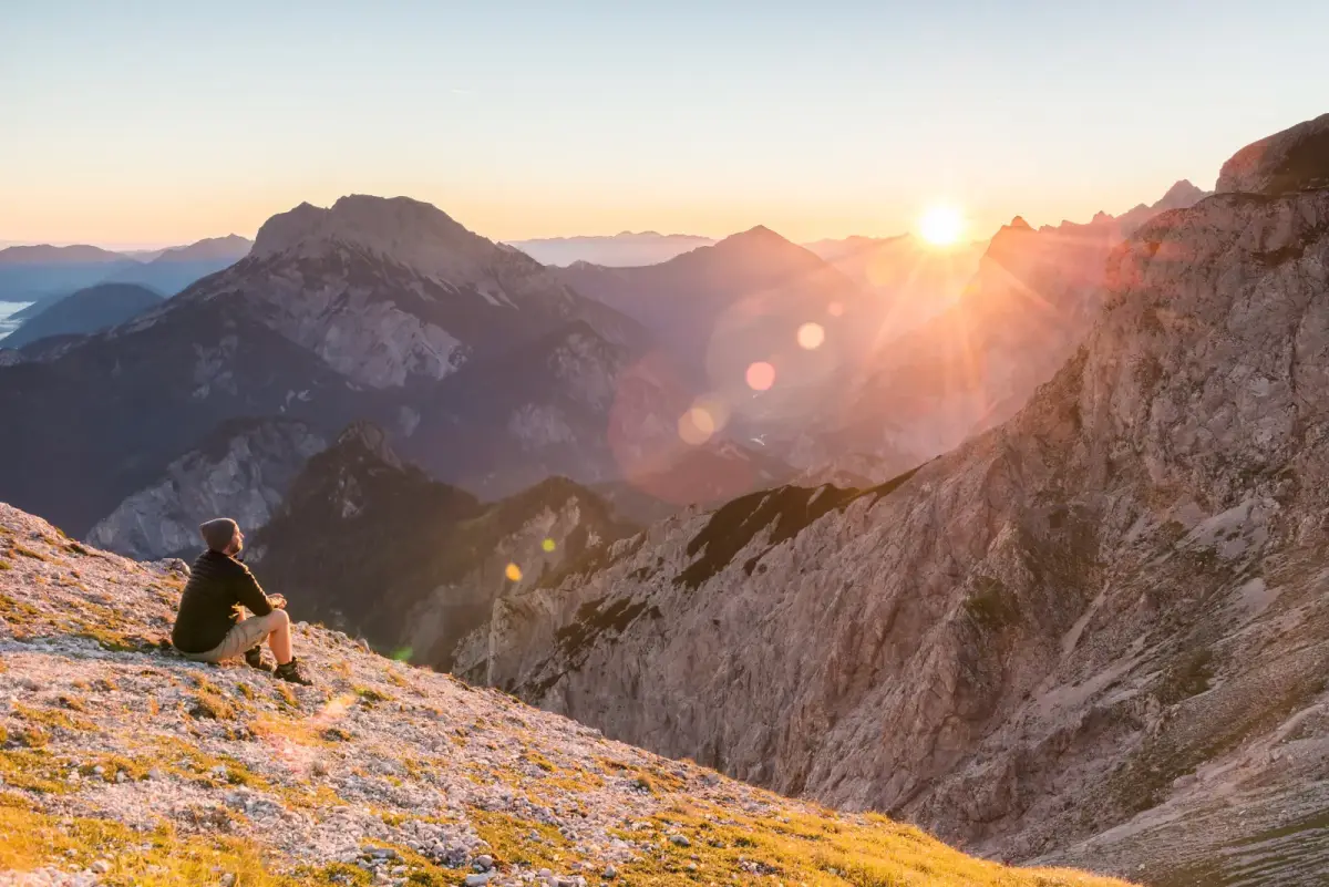 Wanderer auf einem Bergrücken bei Sonnenaufgang im Gesäuse